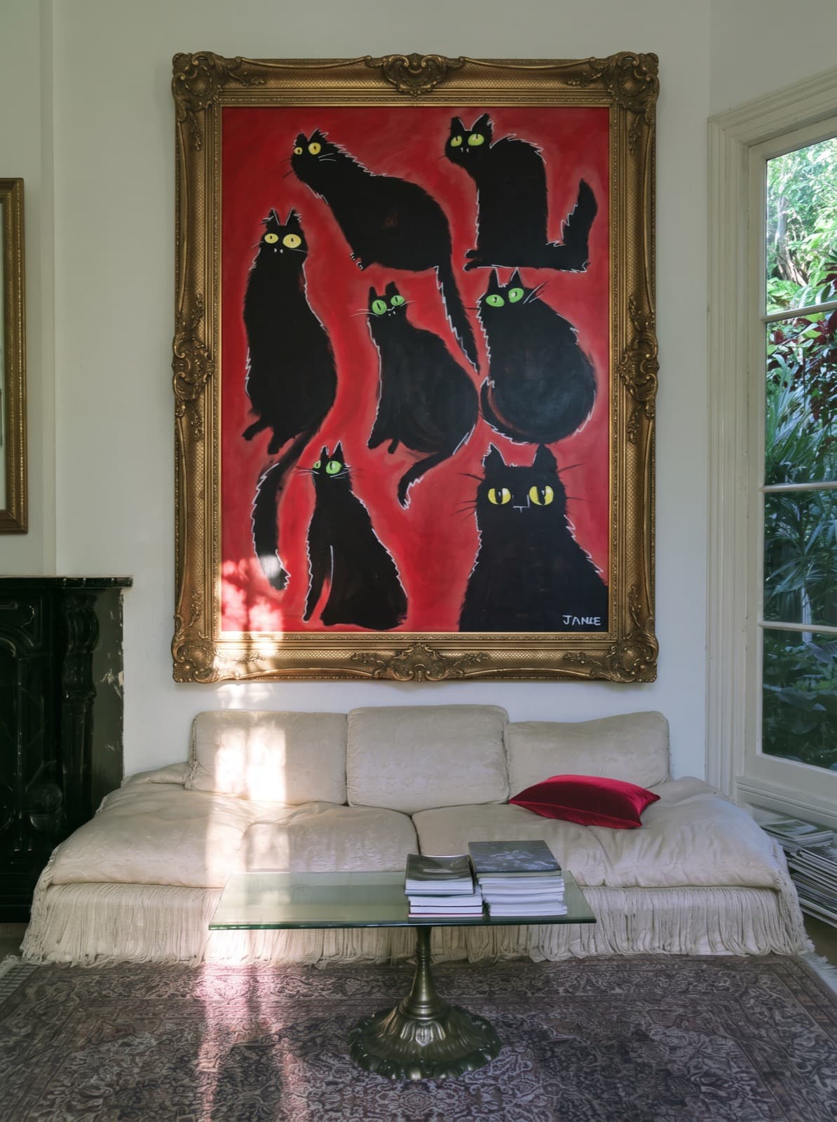 Katten op Rood, an XL oil painting of black cats by Janke de Kock, shown framed above a sofa